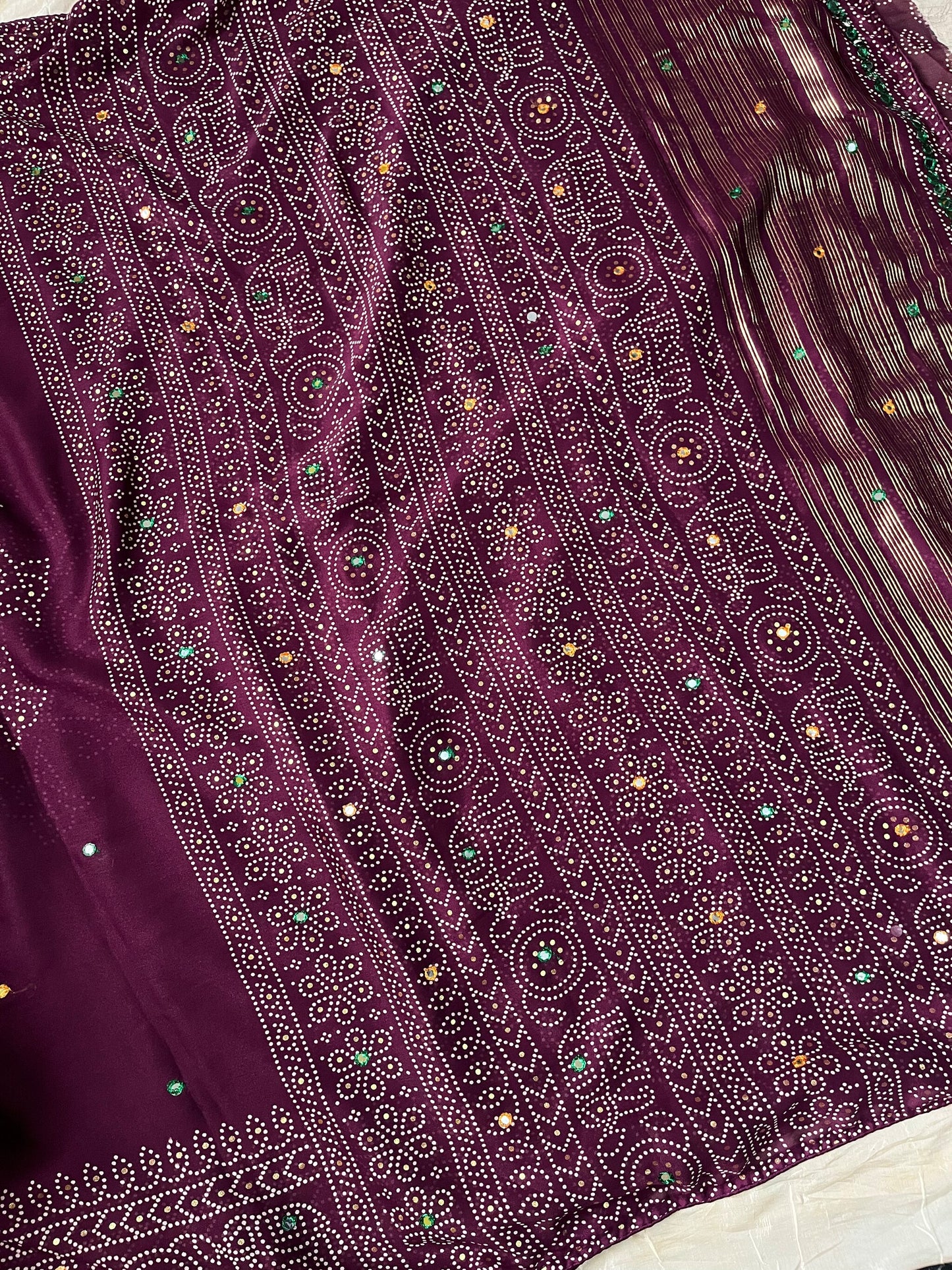 Wine chiffon saree with Bandhani design and all-over mirror work, paired with running blouse