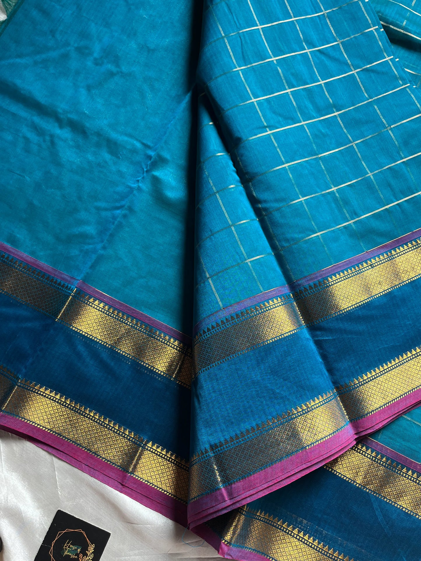 Blue pure Kanchi cotton saree featuring golden zari checks and a grand zari pallu.